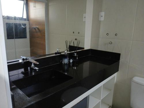 a bathroom with a black sink and a mirror at Flat Av Rio Branco Centro SP in Sao Paulo