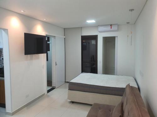a bedroom with a bed and a flat screen tv at Flat Av Rio Branco Centro SP in Sao Paulo