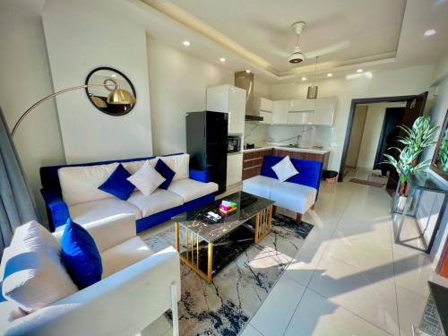 a living room with a white couch and blue pillows at Montressa Hotel Apartments-Elysium Tower Opposite Centaurus Mall Islamabad in Islamabad