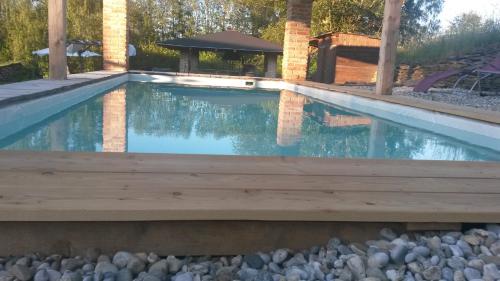 a swimming pool with a wooden deck in a backyard at Apartments Cederika in Věžovatá Pláně