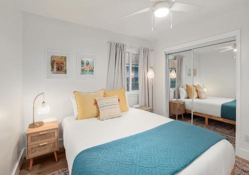 Un dormitorio blanco con una cama y un espejo. en Cozy North Austin Getaway Peaceful Near Domain, en Austin