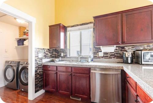 a kitchen with a sink and a washing machine at Pet-Friendly 5BR Near Hospital & TRAX with Projector in Murray