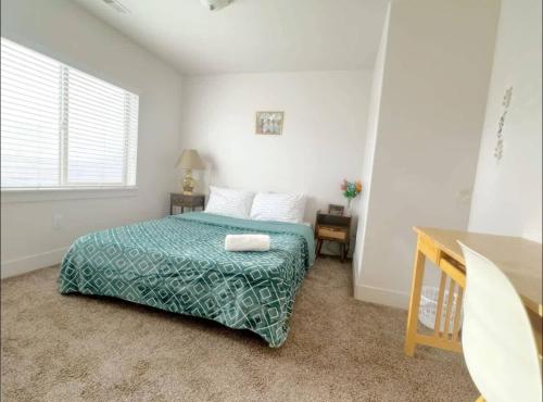 a bedroom with a bed and a table and a window at Pet-Friendly 5BR Near Hospital & TRAX with Projector in Murray