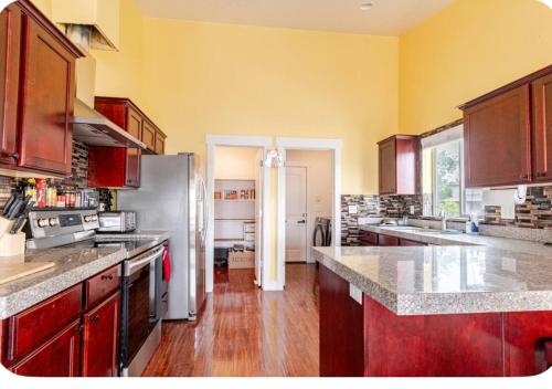 a kitchen with stainless steel appliances and wooden floors at Pet-Friendly 5BR Near Hospital & TRAX with Projector in Murray