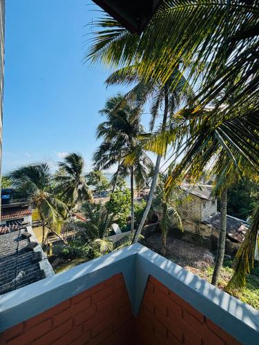 a view of a palm tree from a balcony at SENUKi in Galle