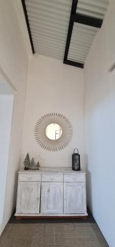 a mirror on a wall with a dresser in a room at The Dutch Barn in Maidstone