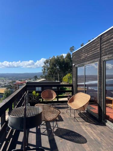a patio with chairs and a table on a deck at Cabañas Refugio Costero in Pelluhue