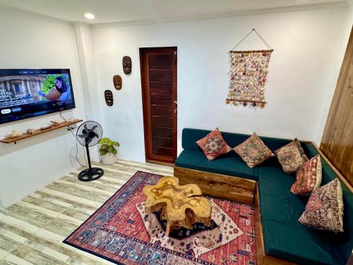 a living room with a blue couch and a tv at Araw Boutique in General Luna