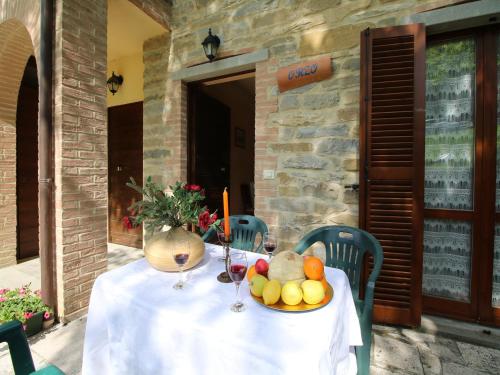 a table with a plate of fruit and wine glasses at Apartment in Marche with Pool & Terrace in Apecchio