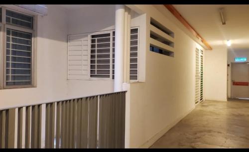 a white building with two windows and a fence at EcoHill Serenity Suites in Semenyih