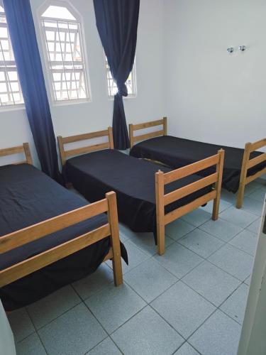 a room with three beds and a window at QUARTO Jd GARCIA in Campinas