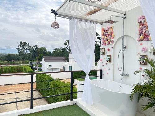 a bathroom with a bath tub on a balcony at Colmar PoolVilla Khao Yai in Wangkata