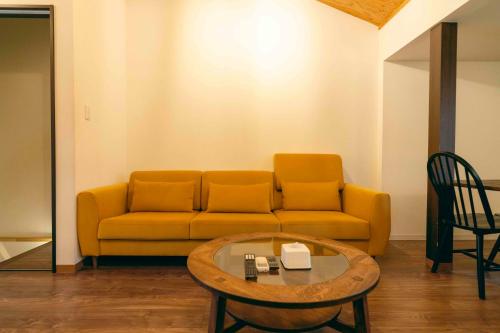 a living room with a couch and a coffee table at TasoneUrbanStayOsaka 梅田中津1 in Osaka