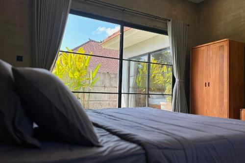 a bedroom with a bed and a large window at Uluwatu Villa Special Price Aug, Sept, Oct in Ungasan