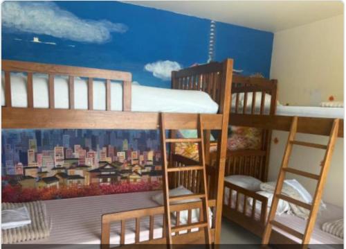 two bunk beds in a room with a mural of a city at Cat Home Ao Nang Landmark in Ao Nang Beach
