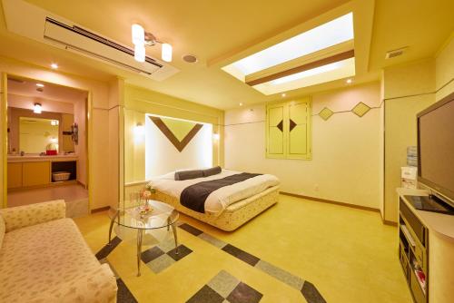 a hotel room with a bed and a living room at HOTEL WiLL EX 大高 レジャーホテル in Nagoya