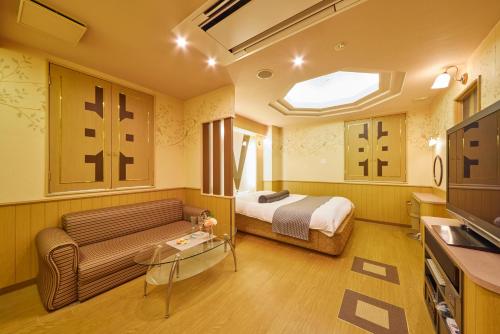a hotel room with a bed and a couch at HOTEL WiLL EX 大高 レジャーホテル in Nagoya