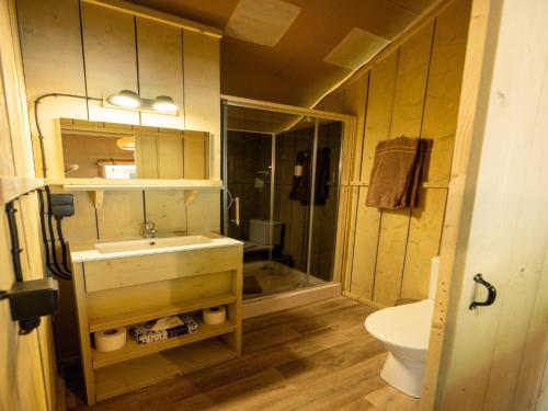 a bathroom with a sink and a shower and a toilet at Luxuszelt im Serengeti Park in Hodenhagen