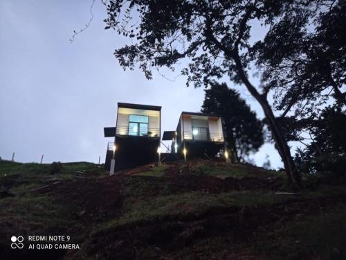 two houses on top of a hill at night at Poás Natural in Alajuela City