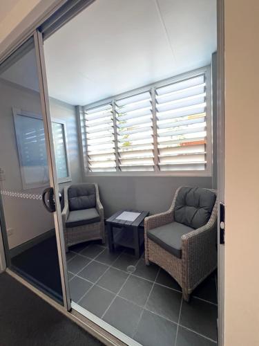 a room with two chairs and a table and windows at Crown on Darby Newcastle in Newcastle