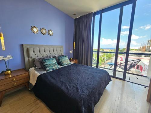 a bedroom with a bed and a large window at Musa 318 in Playa del Carmen