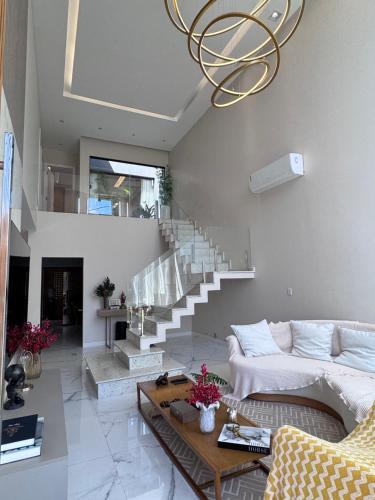 a living room with a couch and a chandelier at Cop30 - casa de luxo no cidade jardim 2 in Belém