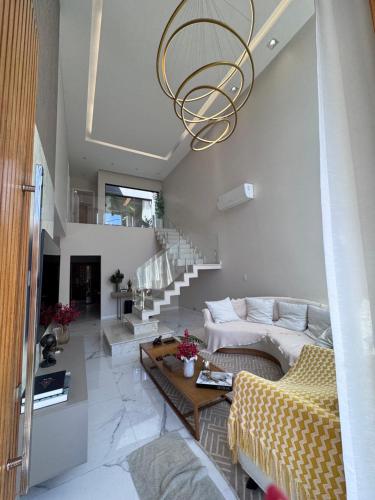 a living room with a couch and a chandelier at Cop30 - casa de luxo no cidade jardim 2 in Belém