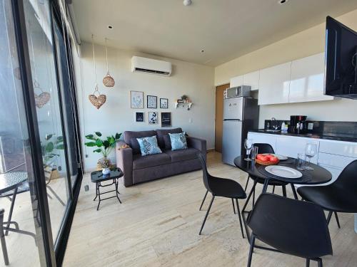a living room with a couch and a table and chairs at Musa 318 in Playa del Carmen