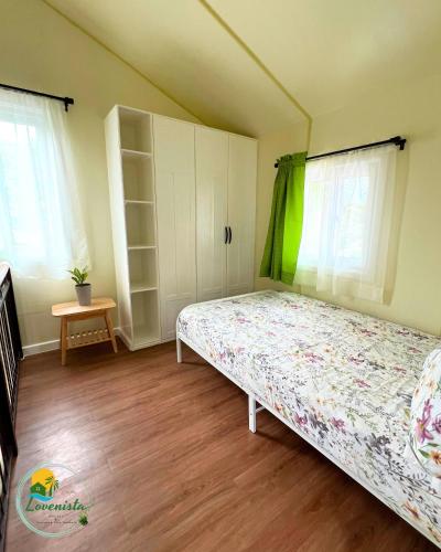 a bedroom with a bed and white cabinets at Lovenista Retreat and Camping Site - Tiny House 