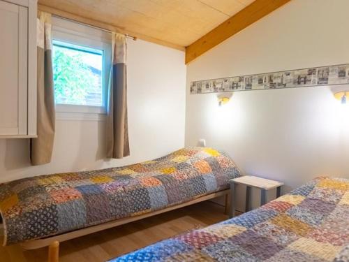 zwei Betten in einem Zimmer mit Fenster in der Unterkunft Chalet 6 personnes avec Terrasse - API-1-52-233 in Fenouillet