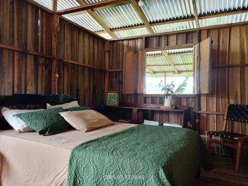 Un dormitorio con una cama en una habitación con paredes de madera. en Home in the mountains, en Tuis