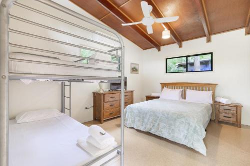 a bedroom with two bunk beds and a ceiling fan at 1770 Southern Cross Travellers Retreat in Agnes Water