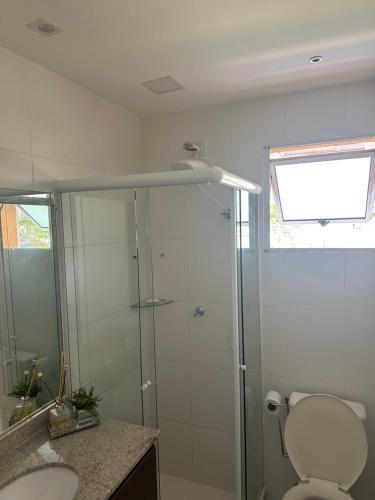 a bathroom with a shower with a toilet and a sink at Village Ducado in Mangaratiba