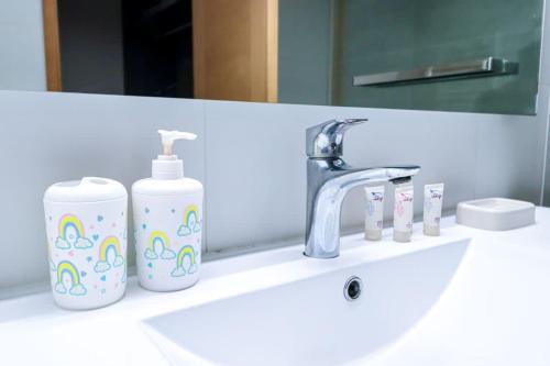 a bathroom sink with two bottles of soap and a mirror at HOM I Conjunto frente a la Costanera 2D2B in Puerto Varas