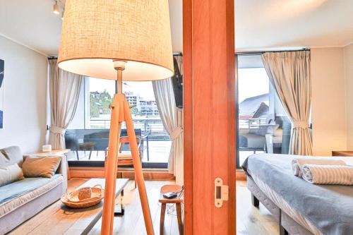 a living room with a floor lamp and a couch at HOM I Conjunto frente a la Costanera 2D2B in Puerto Varas
