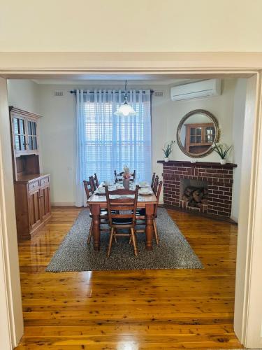 a dining room with a table and chairs and a fireplace at Tamworth suite - Your Boutique Retreat in Dubbo in Dubbo