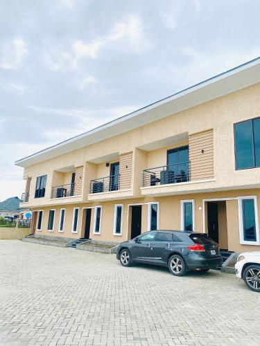 two cars parked in a parking lot in front of a building at Chizzy Shortlets in Warri