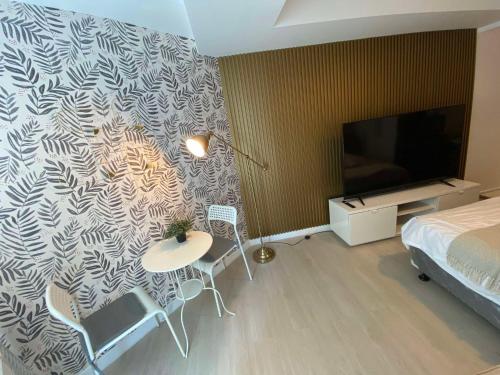 a bedroom with a bed and a tv and a table and chairs at Condo in San Fernando Azure North with Home Theater in San Fernando