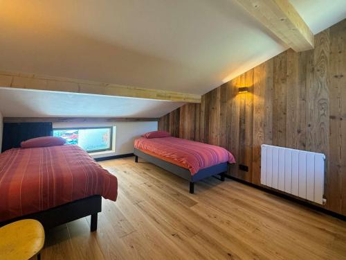 twee bedden in een kamer met houten wanden en houten vloeren bij Chalet spacieux aux Allues, 12 pers., sauna, terrasse - FR-1-180-662 in Les Allues