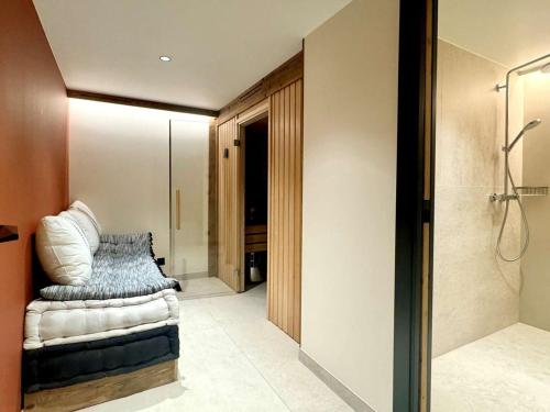 een badkamer met een douche en een bank in een kamer bij Chalet spacieux aux Allues, 12 pers., sauna, terrasse - FR-1-180-662 in Les Allues