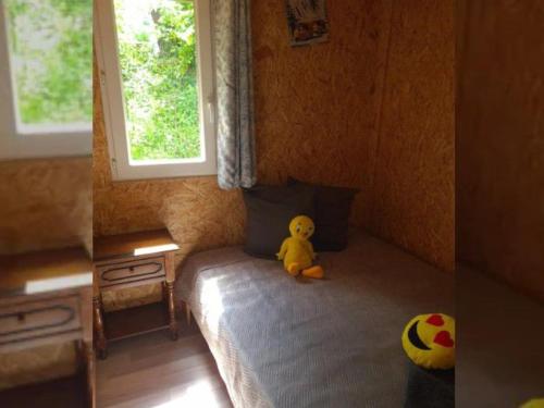 a small yellow toy sitting on a bed in a room at Chalet 50m², 8 personnes, Terrasse - API-1-52-723 in Les Grandes-Ventes
