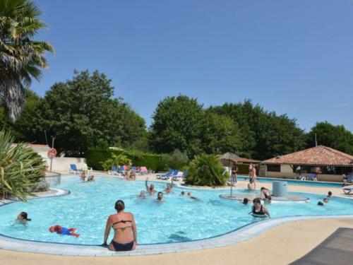 a group of people in a swimming pool at Mobil-home 33m² avec Terrasse - 3 Chambres - API-1-52-682 in Sainte-Eulalie-en-Born
