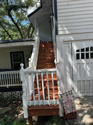 a staircase leading up to a house with white railings at Cici's Guest House in Laurel