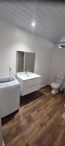 a white bathroom with a sink and a toilet at Fare Coco Tiaré - Jardin Tropical Piscine - Moorea in Afareaitu