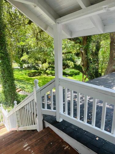 a front porch with a white railing and trees at Cici's Guest House in Laurel
