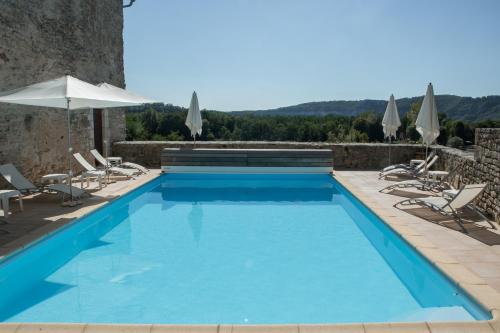 a swimming pool with chairs and an umbrella at Château Hôtel La Terrasse - Teritoria in Meyronne