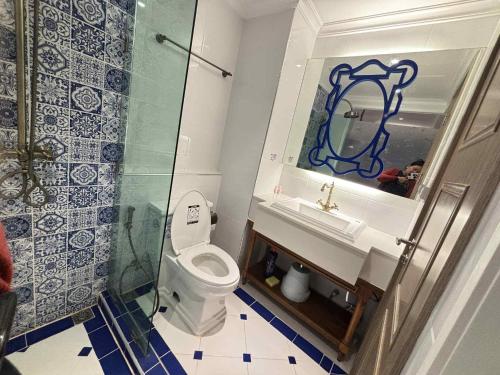 une salle de bain avec toilettes, lavabo et miroir dans l'établissement Blue lagoon seven sea jomtien, à Na Jomtien