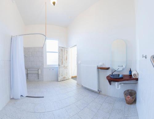 a white bathroom with a shower and a sink at Royal Hotel Coonabarabran in Coonabarabran