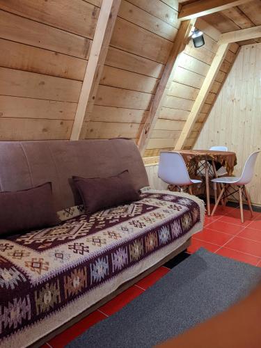 a bed in a room with a table and chairs at Tri breze in Kolašin