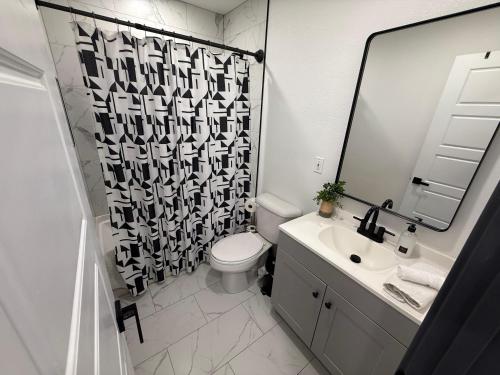 a bathroom with a toilet and a sink and a mirror at Cozy Guest House in amazing Las Vegas in Las Vegas